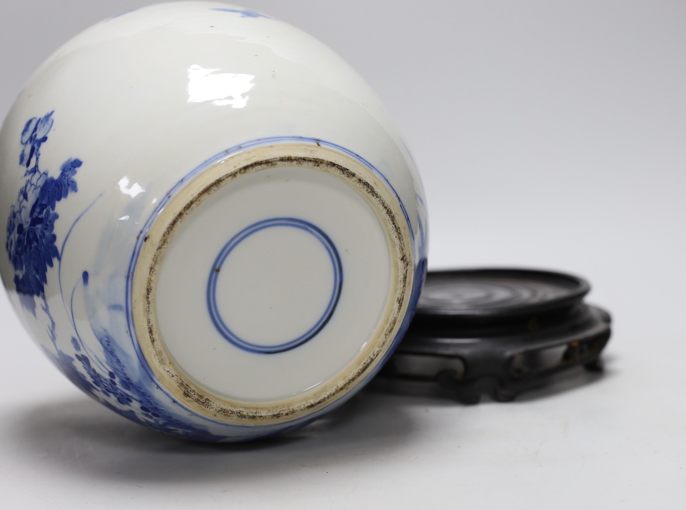 A large Chinese blue and white porcelain jar, 19th century decorated with scenes of birds amongst foliage with associated pierced hardwood cover and stand, 29cms high including stand and cover